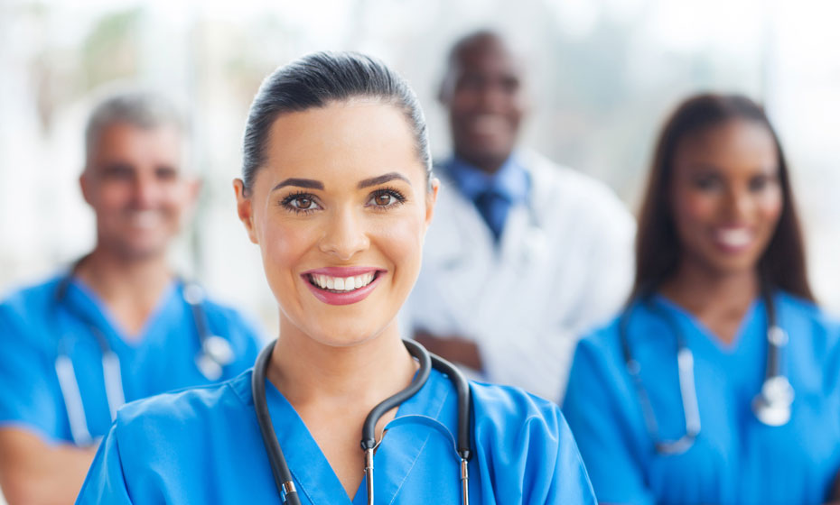 Portrait of a female nurse with a group of nurses blurred out in the background